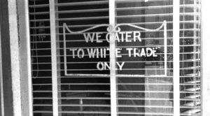 black and white photo showing a "whites only" sign circa 1943