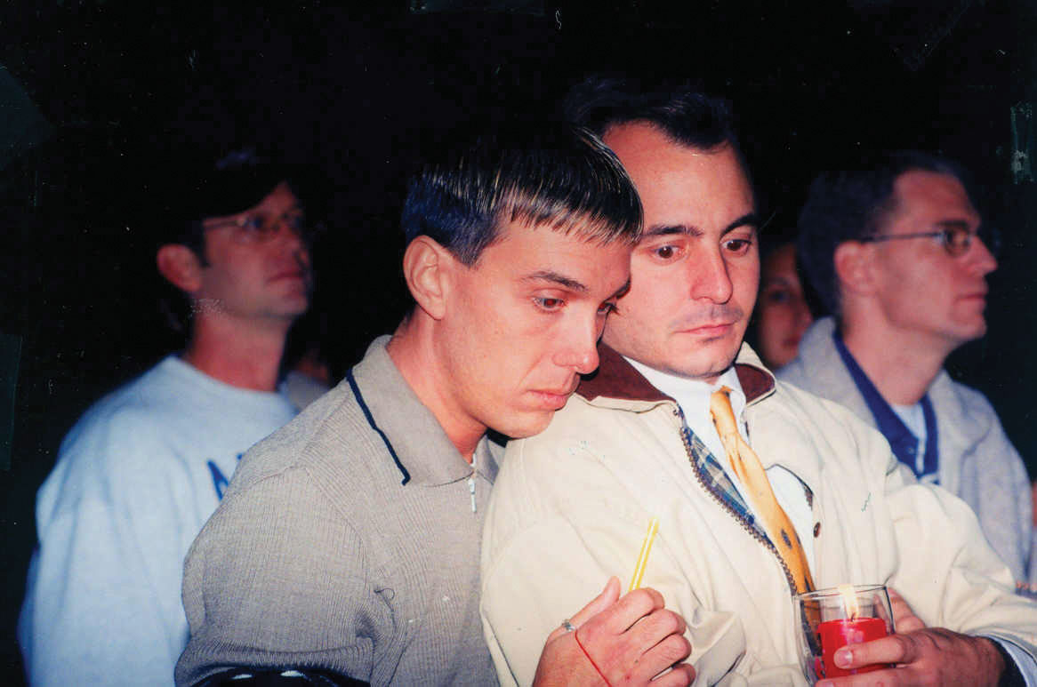 A group of men gathered at a candlelight vigil in memory of Matthew Shepard, a gay college student who was tortured, tied to a fence, and left to die in Wyoming.