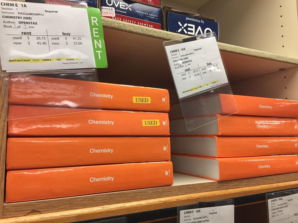 Copies of OpenStax’s “Chemistry” book line the shelves of the Harvard Bookstore. Prices for used and new copies of the text are displayed.